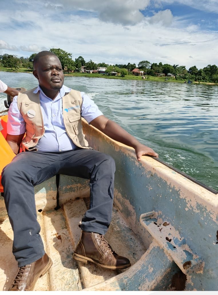 A NATE Africa field team member in a branded vest travelling by boat across a lake to reach a study site