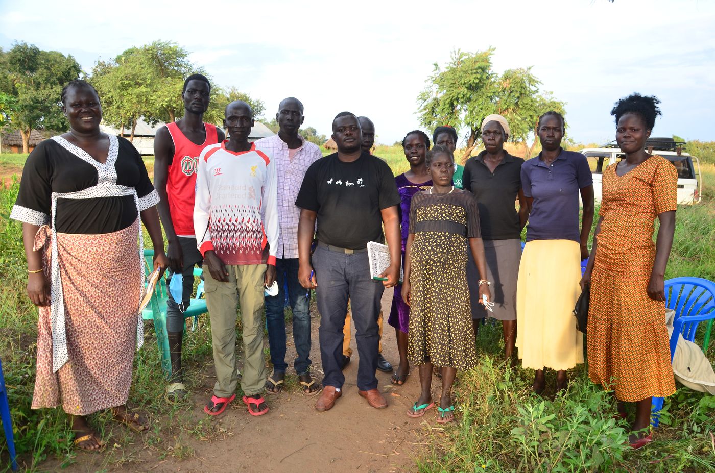 Focus group discussion participants standing together with a NATE Africa researcher in a rural community