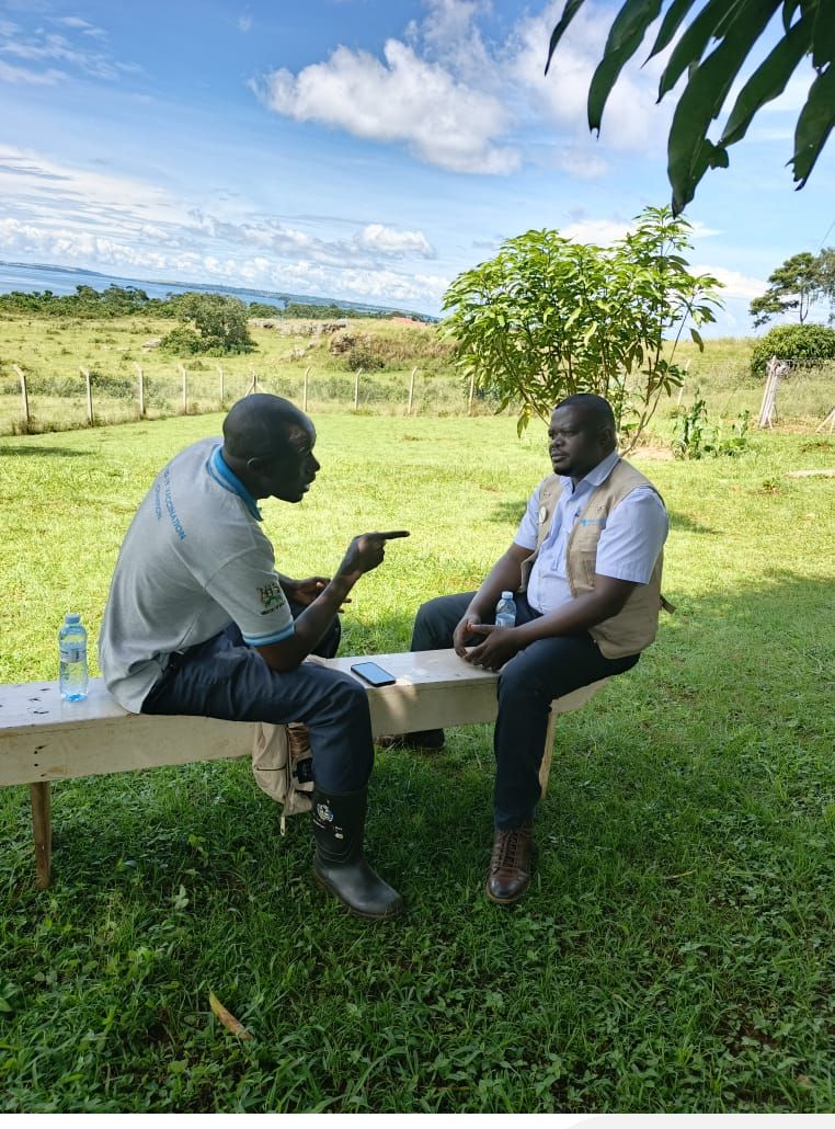 A NATE Africa researcher holding a key informant interview on a bench overlooking a lake